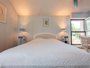 een slaapkamer met een wit bed en 2 lampen bij Chambre "Bleue", Les Gabettes in Velles