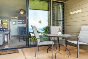 un patio con tavolo e sedie su un portico di Polynesian Shores 112 a Kahana