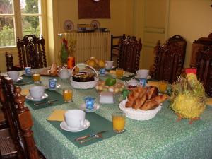 een tafel met een tafelkleed met brood en sinaasappelsap bij Chambre "Bleue", Le Priouzé in Chézelles