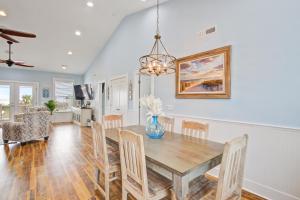 a dining room and living room with a table and chairs at LaiDDback in Folly Beach