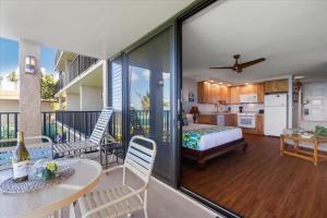 une chambre avec un lit et un balcon avec une cuisine dans l'établissement Papakea A206, à Kahana