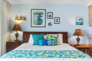 - une chambre avec un lit doté d'oreillers bleus et verts dans l'établissement Papakea A206, à Kahana