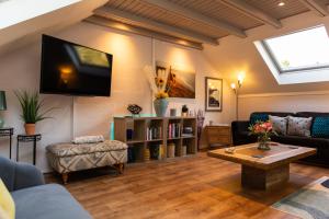 a living room with a couch and a tv on the wall at 1 Bedroom studio with free parking in Truro