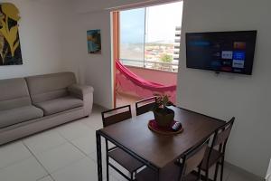 ein Wohnzimmer mit einem Tisch und einem Sofa in der Unterkunft Apartamento beira-Mar em Natal in Natal
