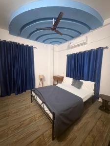a bedroom with a bed with a blue ceiling at Retrova - Forest Villa near Rajpur Road in Rājpur +16 photos