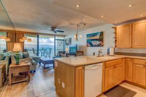 a kitchen and living room with a view of the ocean at Kahana Reef 321 in Kahana