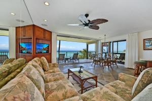 un soggiorno con un divano e un ventilatore a soffitto di Noelani 210 a Kahana