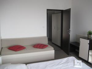 Un dormitorio con una cama con dos almohadas rojas. en Penzion Nad Zámeckou zdí, en Trhový Štěpánov