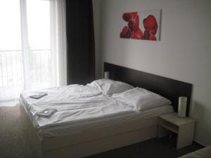 Un dormitorio con una cama blanca con una ventana. en Penzion Nad Zámeckou zdí, en Trhový Štěpánov 3 fotos más