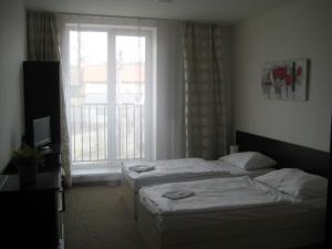 Dos camas en una habitación de hotel con ventana. en Penzion Nad Zámeckou zdí, en Trhový Štěpánov