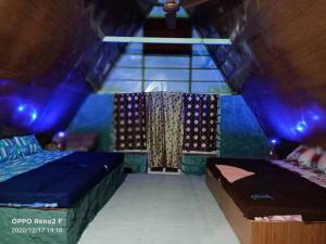 een kamer met twee bedden en een trap met blauwe lampen bij Green hut house in Yelagiri