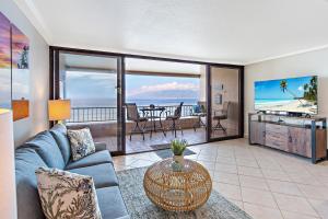 a living room with a couch and a table at Maui Kai 504 in Kahana