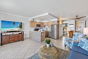 a living room with a blue couch and a kitchen at Maui Kai 504 in Kahana