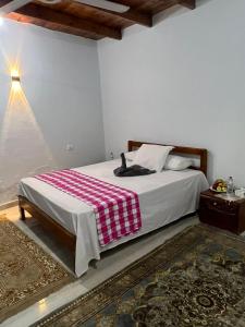 a bedroom with a bed with a red and white blanket at Nile Flower Guesthouse in Luxor