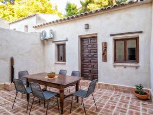 een patio met een houten tafel en stoelen bij Casa de La Canita in Guadamur