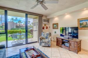 a living room with a tv and a couch at Kamaole Sands 2-106 in Wailea