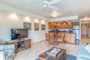 a living room with a couch and a tv and a table at Kamaole Sands 2-106 in Wailea