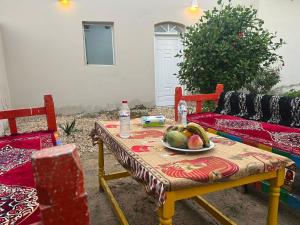 a table with a bowl of fruit on it at Nile Flower Guesthouse in Luxor