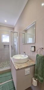 ein weißes Badezimmer mit Waschbecken und Dusche in der Unterkunft Swakopmund Central Garden Guest House in Swakopmund + 79 Fotos