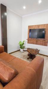 ein Wohnzimmer mit Sofa und Flachbildfernseher in der Unterkunft Swakopmund Central Garden Guest House in Swakopmund
