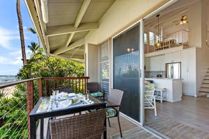 a balcony of a house with a table and chairs at Hale Kai 220 in Kahana