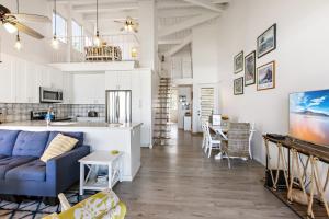 a living room with a blue couch and a kitchen at Hale Kai 220 in Kahana