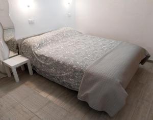 Casa Cozy - Comodo Appartamento in Asti Centro في آستي: غرفة نوم صغيرة بها سرير وكرسي