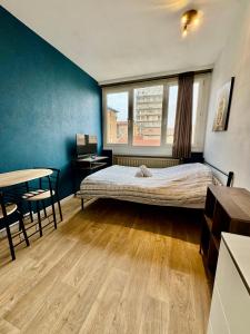 Un dormitorio con una cama, un escritorio y una mesa. en Hyper Centre de Valence - Studio N32, en Valence