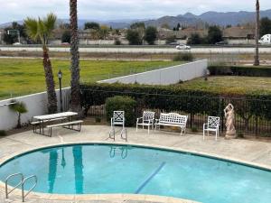 Una mujer está de pie junto a una piscina. en SureStay by Best Western Morgan Hill, en Morgan Hill