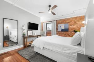 a bedroom with a white bed and a brick wall at West End Loft - Downtown 5 min walk to River St in Savannah +34 photos