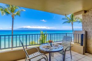 Un balcón con mesa y sillas y el mar. en Paki Maui 302A, en Honokowai
