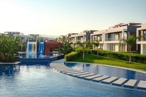 a pool with a water slide in a resort at Spacious & Bright 2BR Apartment, 5min to Beach in Boghaz