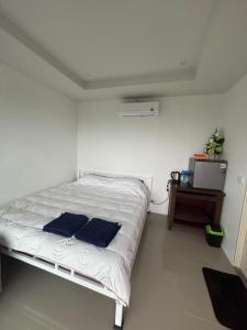 a bedroom with a bed with two blue pillows on it at Mong Do Lay Baan Sea View in Ban Ao Makham