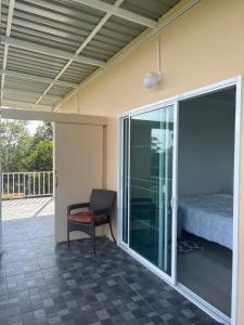 a room with a bed and a chair on a patio at Mong Do Lay Baan Sea View in Ban Ao Makham