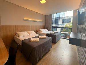 a hotel room with two beds and a window at Pousada Duas Ilhas in Penha