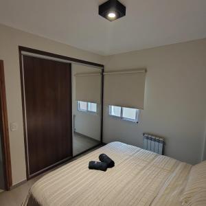 una camera da letto con un letto grande con un grande specchio di departamento premium de 3 Ambientes a Pinamar