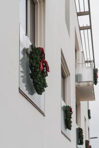Una hilera de ventanas con coronas navideñas. en Hôtel de La Plage, en Biarritz