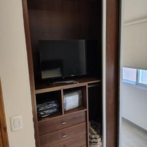 un centro di intrattenimento con TV a schermo piatto in camera di departamento premium de 3 Ambientes a Pinamar