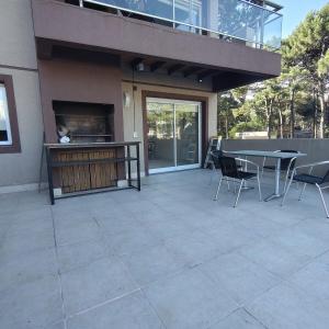 un patio con tavolo e sedie accanto a un edificio di departamento premium de 3 Ambientes a Pinamar