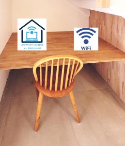 a wooden table with a wooden chair in front of a desk at Le clos du prieuré - Les Gîtes de la Côte d'Amour in Batz-sur-Mer