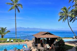 a resort with a swimming pool and palm trees at Noelani 113 in Kahana
