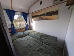 a bed in a small room with a window at Auszeit im Bauwagen in Arnsdorf