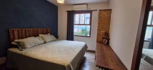 a bedroom with a bed and a window at Home 013 in São Vicente