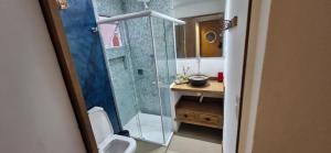 a bathroom with a shower and a toilet and a sink at Home 013 in São Vicente +25 photos