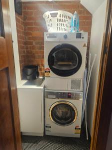 a washer and a washing machine in a room at Renovated 1930's home in Sandy Bay