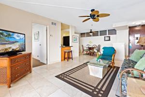 a living room with a couch and a tv at Royal Kahana 1212 in Kahana