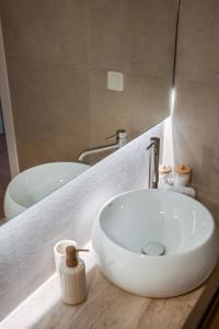 a bathroom with a white sink and a tub at 14 luxury apartment in Preveza +17 photos