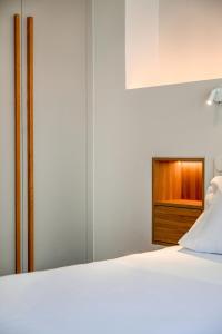 a bedroom with a white bed and a wooden dresser at 14 luxury apartment in Preveza