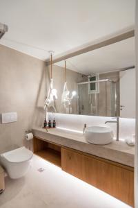 un bagno con lavandino, WC e specchio di 14 luxury apartment a Preveza