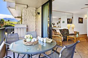 a living room with a table and chairs on a balcony at Paki Maui 326 in Honokowai